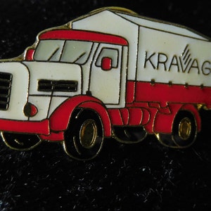 Peut inclure: Une épingle en émail rouge et blanche représentant un camion avec le mot "KRAVAG" sur le côté.