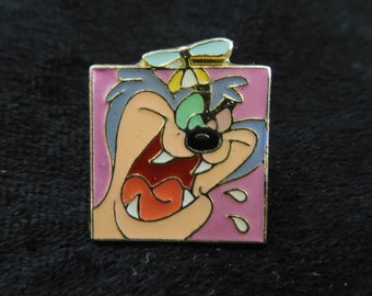 May include: A cartoon character with a pink background and a propeller hat. The character has a wide open mouth with a red tongue and white teeth. The character has a green eye and a black nose.