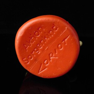 May include: Orange round soap bar with the text "Aktien Sorgenkind" and "Verbot" on it.