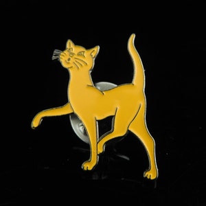 Könnte beinhalten: Eine gelbe Emaille-Anstecknadel mit einem schwarzen Umriss eines Katers. Der Kater steht auf seinen Hinterbeinen und hat seine Vorderpfote erhoben.
