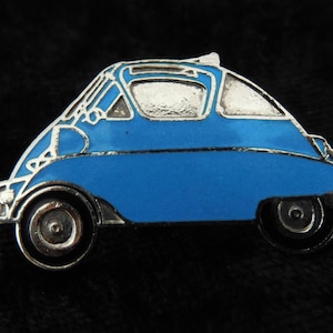 Peut inclure: Une épingle en émail bleu en forme de voiture ancienne. La voiture a un toit et des roues argentés.