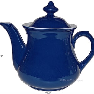 May include: A cobalt blue ceramic teapot with a white rim and lid. The teapot is 8 1/2 inches tall and 9 1/2 inches wide.