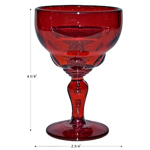 May include: A red glass goblet with a wide bowl and a tall stem. The goblet is 4 1/4 inches tall and 2 3/4 inches wide.