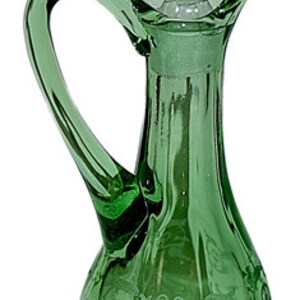 May include: A green glass bottle with a clear glass stopper and a decorative etched design. The bottle has a handle and a round base.