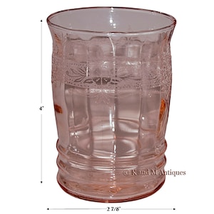May include: A pink glass tumbler with a textured design and a 4-inch height and 2 7/8-inch diameter.  © K and M Antiques