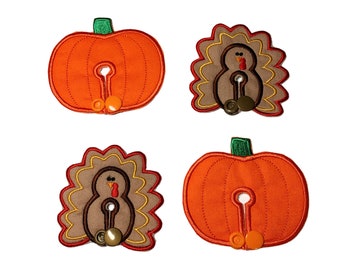 May include: Four fabric patches with Thanksgiving themes. Two patches feature a pumpkin design with a brown stem and orange fabric. Two patches feature a turkey design with a brown body, red wattle, and yellow and brown feathers.