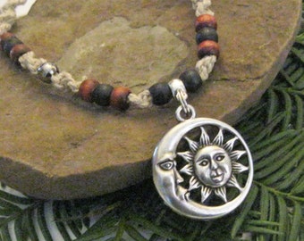 May include: A hemp necklace with black and red wooden beads and a silver pendant featuring a sun and moon design.