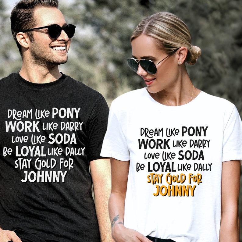 K&ouml;nnte beinhalten: Zwei schwarz-wei&szlig;e T-Shirts mit dem Text "DREAM LIKE PONY WORK LIKE DARRY love LIKE SODA BE LOYAL LIKE DALLY STAY GOLD FOR JOHNNY" darauf gedruckt. Der Text ist in Schwarzwei&szlig;, wobei die W&ouml;rter "STAY GOLD FOR" in Gold gehalten sind.