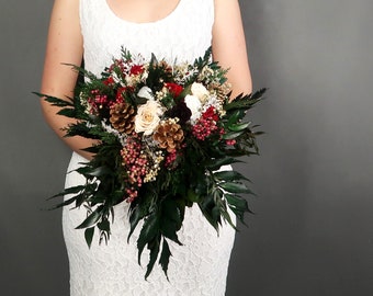 Cascading winter wedding bridal bouquet with pine cones, berries and real roses in red, burgundy, white, champagne, woodland greenery