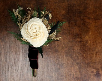 Winter wedding woodland boutonniere with ivory sola rose, pine cones, gold dried flowers and preserved woodland greenery