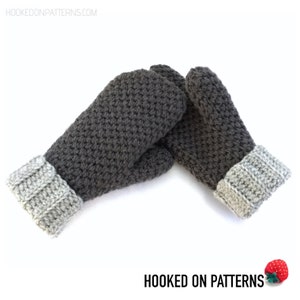 May include: A pair of gray crocheted mittens with a gray and white crocheted cuff. The mittens are made with a textured stitch and are perfect for keeping your hands warm in the winter.