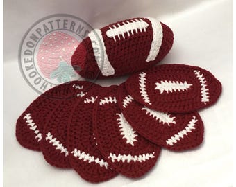 May include: A set of crocheted footballs in maroon and white. The set includes a larger football and six smaller footballs.