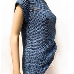 May include: A blue crochet top with a crocheted neckline and short sleeves. The top is made with a stitch pattern that creates a textured look.