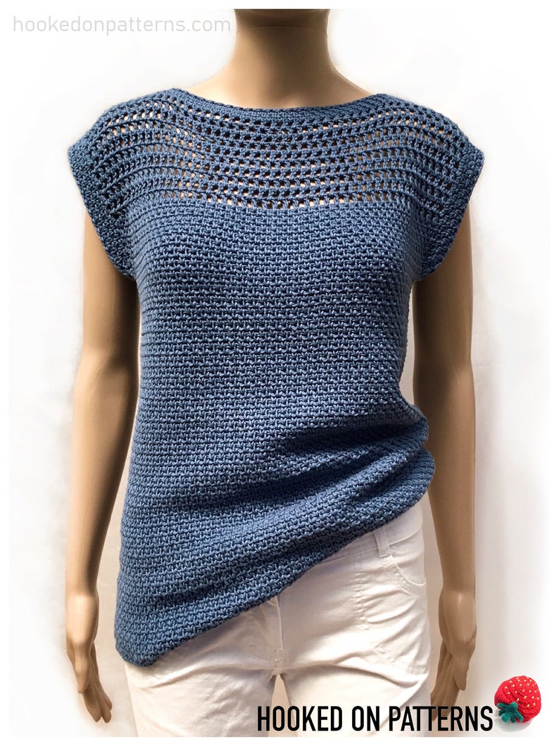 May include: A blue crochet top with a crocheted neckline and short sleeves. The top is made with a stitch that creates a textured look. The top is displayed on a mannequin.