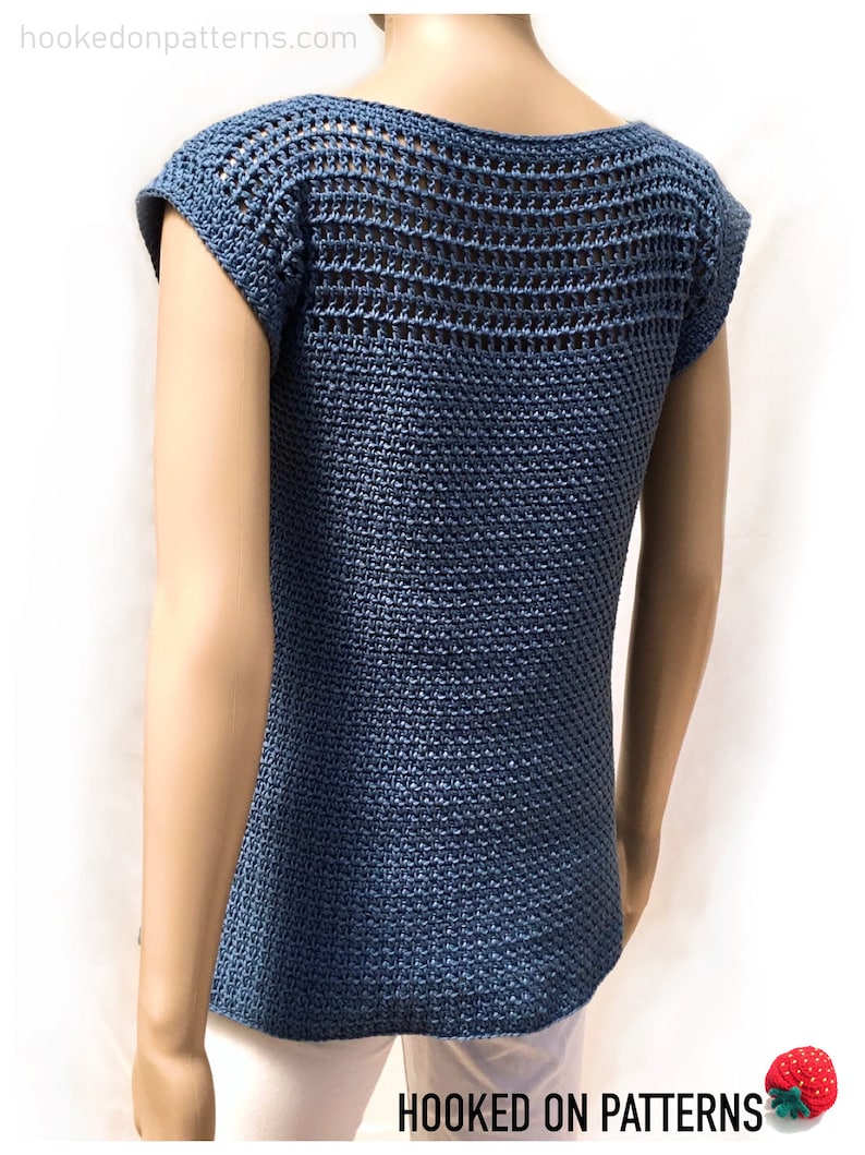 May include: A blue crochet top with a mesh design on the back and short sleeves. The top is shown on a white mannequin.