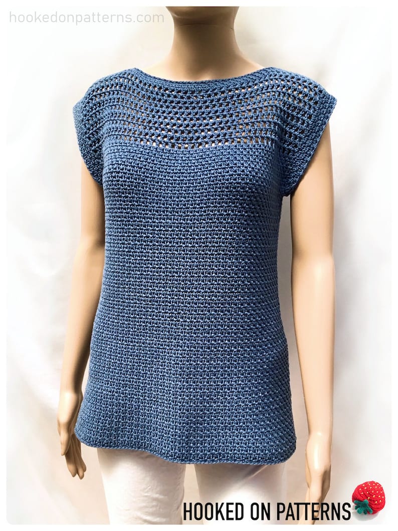 May include: A blue crochet top with a loose fit and short sleeves. The top has a delicate openwork pattern around the neckline.