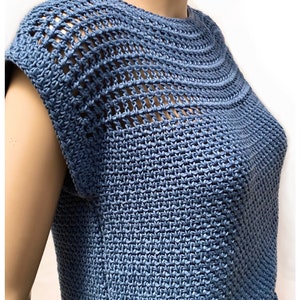 May include: A blue crochet top with a crocheted neckline and short sleeves. The top is made with a stitch pattern that creates a textured look. The text "HOOKED ON PATTERNS" is visible in the top right corner of the image.