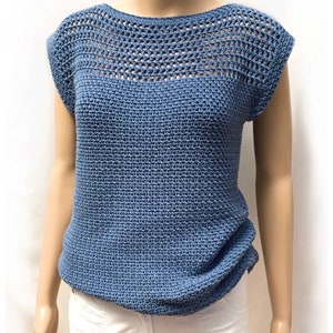 May include: A blue crochet top with a crocheted neckline and short sleeves. The top has a textured stitch pattern and is shown on a mannequin.