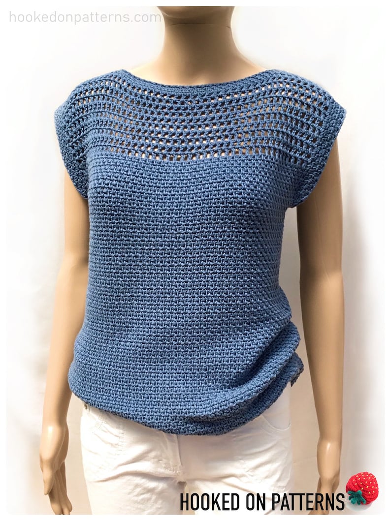 May include: A blue crochet top with a crocheted neckline and short sleeves. The top has a textured stitch pattern and is shown on a mannequin.