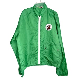 May include: Bright green nylon jacket with a white zipper and a small pocket on the chest. A circular patch featuring a horse head and horseshoe is on the upper left chest. The jacket is hanging on a white hanger.