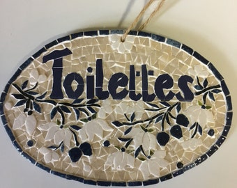 Plaque de porte en mosaïque "Toilettes" tons bleus et écrus, branche fleurie blanche et petits fruits bleus avec cordelette d'accrochage.