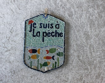 Placa de puerta: "Estoy pescando" en mosaico. Río lleno de peces sobre un soporte de madera pintada y cuerda para colgar.