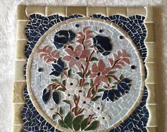 Dessous de plat en mosaïque: bouquet d'anémones bleues et de clématites roses. 20cmx20cm sur un carreau de faïence.