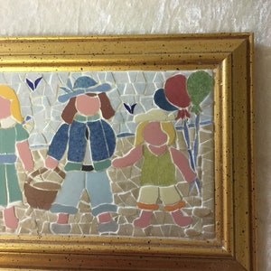 Puede incluir: Una obra de arte de mosaico enmarcada que representa a tres ni&ntilde;os con globos de colores. Los ni&ntilde;os visten ropa azul, verde y rosa. El mosaico est&aacute; hecho de peque&ntilde;os azulejos de colores.