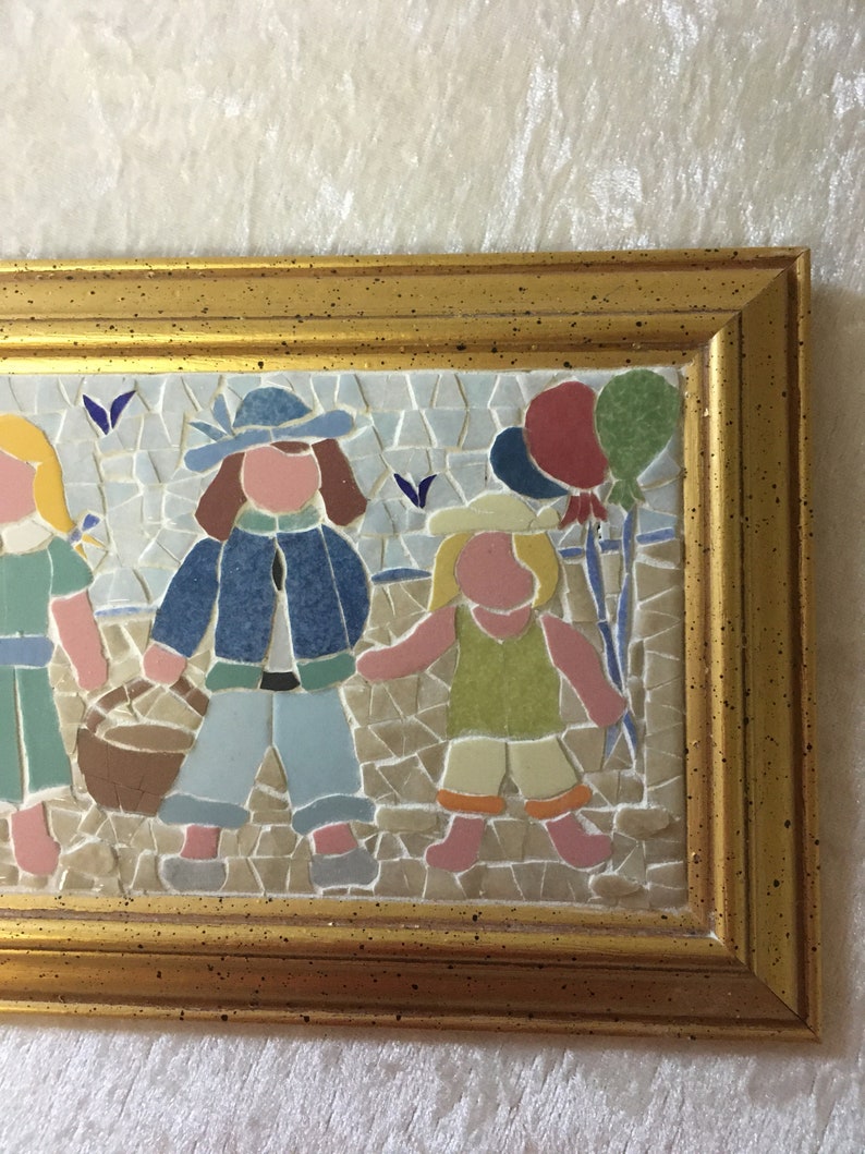 Puede incluir: Una obra de arte de mosaico enmarcada que representa a tres ni&ntilde;os con globos de colores. Los ni&ntilde;os visten ropa azul, verde y rosa. El mosaico est&aacute; hecho de peque&ntilde;os azulejos de colores.