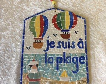 Plaque de porte mosaïque: "Je suis à la plage", décor marin. Deux Montgolfières et un marin. Cordelette d'accrochage et perles de verre.