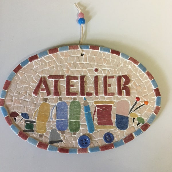 Plaque de porte en mosaïque: "Atelier". Petits outils de couture et boutons sur un support en bois peint avec cordelette d'accrochage .