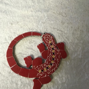 Ronde rode mozaïekhagedis. Houten standaard. Haakje om op te hangen aan de achterkant. Om neer te zetten of op te hangen: 13 cm x 13 cm.