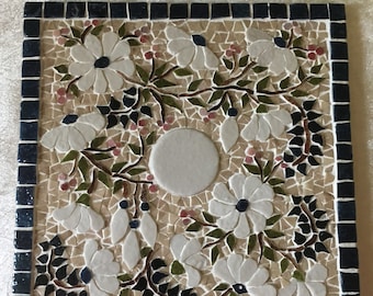 Dessous de plat en mosaïque, 20cm x20cm. Parterre de marguerites blanches en relief et volutes bleues . Support carreau de faïence.