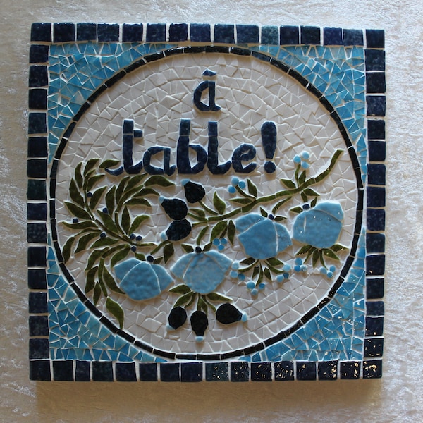 Dessous de plat en mosaïque: "A table!". Décor de fleurs bleues en relief. 20cmx20cm . Résistant à l'eau et à la chaleur.