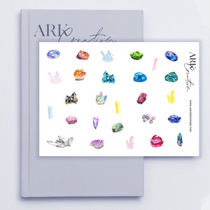 May include: A sheet of stickers featuring 25 different watercolor illustrations of crystals and gemstones. The stickers are arranged in a grid pattern on a white background. The text "ARK Creation" appears in the top right corner of the sheet.