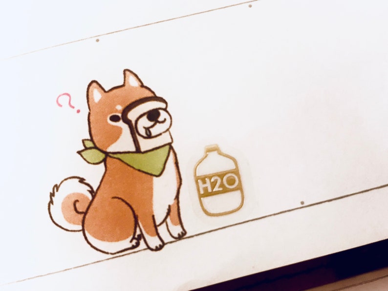 May include: A cartoon illustration of a brown and white dog wearing a green bandana and holding a slice of bread in its mouth. The dog is looking up with a questioning expression. A small bottle with the text "H2O" is to the right of the dog.