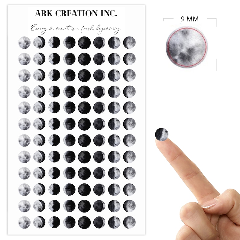 May include: Sheet of stickers featuring phases of the moon in grayscale. Each sticker is a circle, approximately 9 mm in diameter. The sheet has the text "ARK CREATION INC." and "Every moment is a fresh beginning."