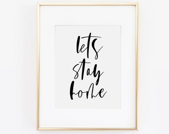 May include: A gold framed print with the text "Let's Stay Home" in black calligraphy.