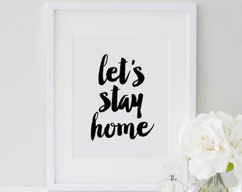 May include: White framed print with black calligraphy that reads "let's stay home".