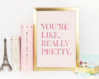 May include: A gold framed print with a pink background and the text "YOU'RE LIKE, REALLY PRETTY." in pink lettering.
