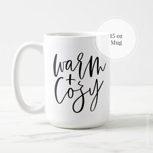 May include: White ceramic mug with black text that reads "warm + cozy" on a white background. The mug is 15 ounces.