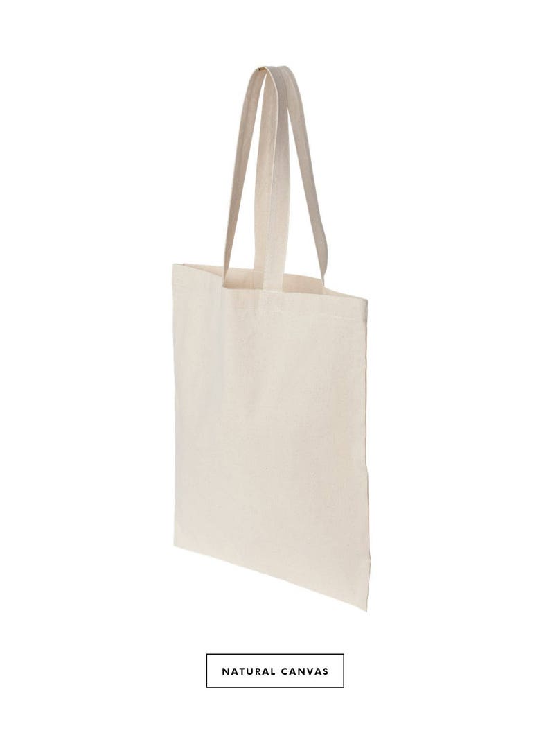 May include: A plain white tote bag with two long handles. The bag is made of natural canvas.