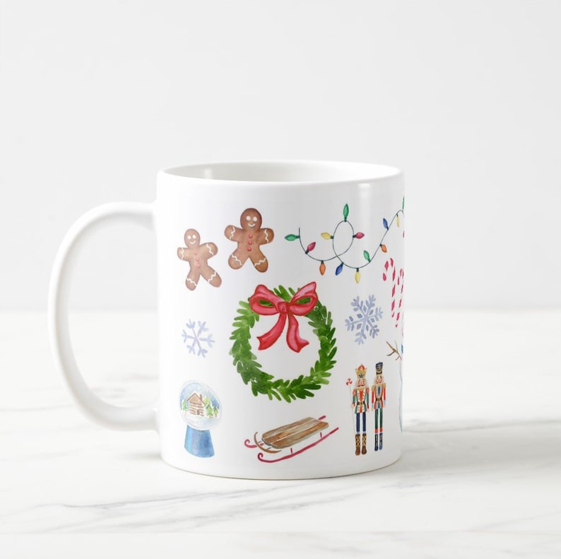 May include: White ceramic mug with a Christmas theme design. The design features gingerbread men, a wreath with a red bow, a snow globe, a sled, candy canes, snowflakes, and a nutcracker.