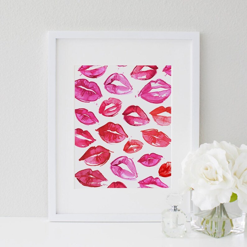May include: A framed print with a watercolor painting of pink and red lips on a white background.