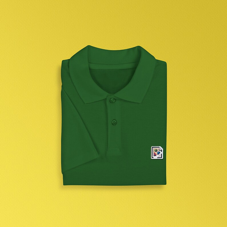 K&ouml;nnte beinhalten: Ein dunkelgr&uuml;nes Poloshirt mit einer kleinen, bunten Grafik auf der rechten Brustseite.