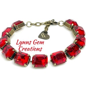May include: A red gemstone bracelet with a vintage bronze finish. The bracelet features rectangular red gems set in a bronze metal frame. The text "Lynns Gem Creations" is visible on the image.