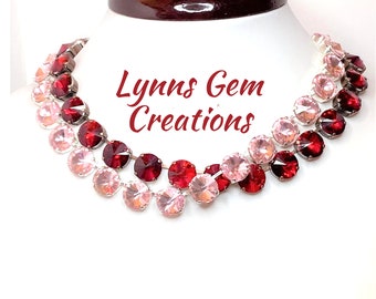 Puede incluir: Un collar de dos hilos con gemas rosas y rojas alternas. Las gemas redondas están engastadas en un metal plateado. El texto "Lynns Gem Creations" se muestra en cursiva roja.