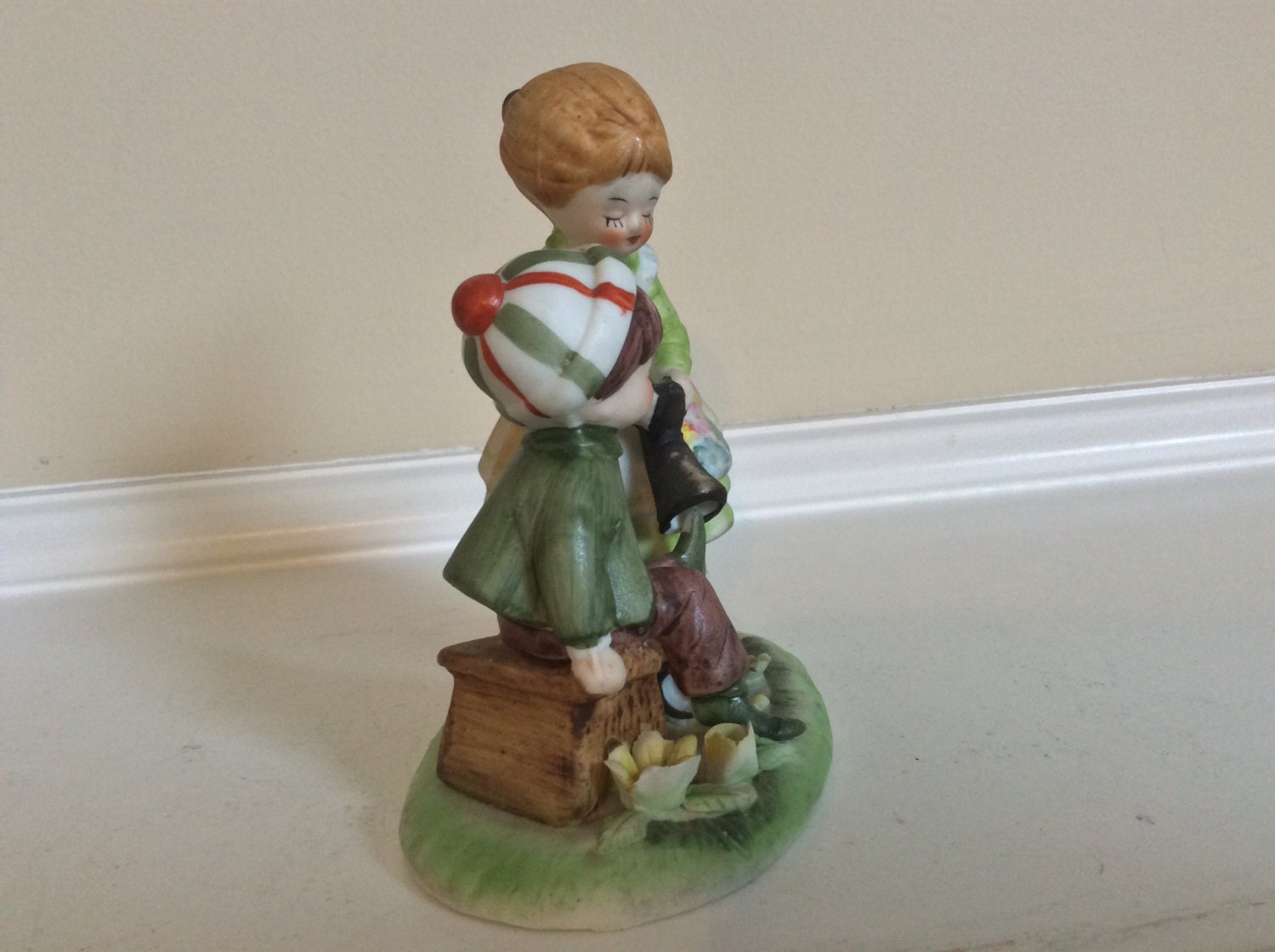A Cute Figurine of a Mother Helping Her Child Take off His Boots. -   Australia