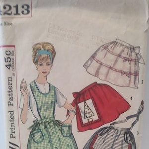 May include: A vintage sewing pattern for aprons. The pattern includes three different styles: a gingham apron with pockets, a red apron with a Christmas tree design, and a striped apron with a bow. The pattern is printed on paper and includes instructions for sewing the aprons.