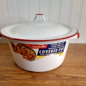 May include: White enamel covered pot with a red rim and a handle. The pot has a sticker on the side that says "Columbian Ware Covered Pot Titanium Added for Longer Wear and Permanent Water Tight Seal".